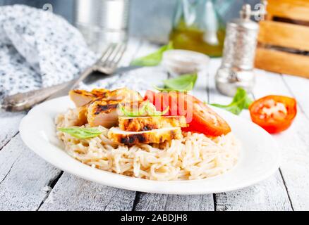 Des pâtes avec du poulet et tomate fraîche Banque D'Images