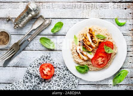 Des pâtes avec du poulet et tomate fraîche Banque D'Images