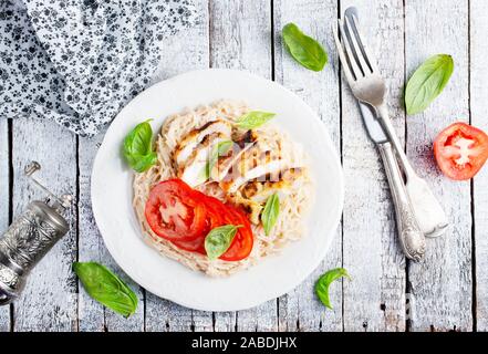 Des pâtes avec du poulet et tomate fraîche Banque D'Images