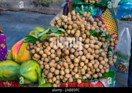 Pile de langsat fruits sur la rue du marché. Arrière-plan de fruits tropicaux exotiques Banque D'Images