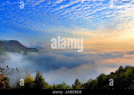 L'échelle à poissons-comme cloud, également connu sous le nom de Altocumulus translucidus, qui indique que l'air froid sévère, plane sur la montagne jaune, formant un merveilleux na Banque D'Images