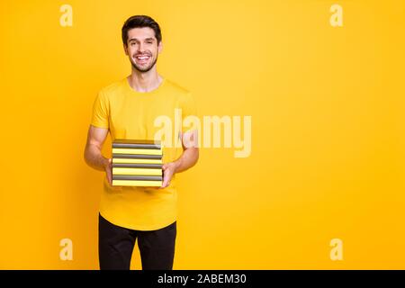 Portrait de sa belle belle belle il Gai gai guy brunette holding en mains pile de livre plus isolés vivid shine lumineux vibrant jaune Banque D'Images