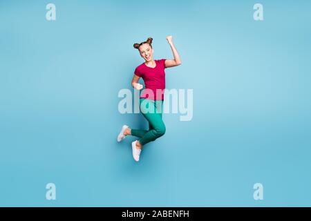 Toute la longueur de la taille du corps tourné photo de joie extatique excité girl wearing red t-shirt pantalon pantalon vert criant ouais dans sneakers isolated Banque D'Images