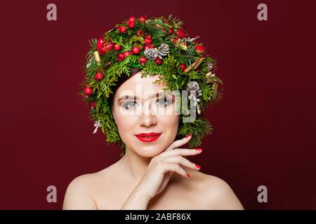 Jolie femme dans un décor de Noël sur fond rouge Banque D'Images