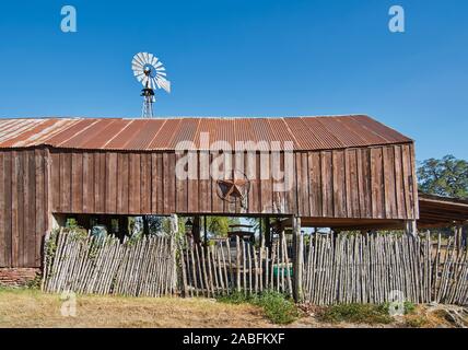 Une ancienne grange en bois avec un maigre à toit de tôle rouillée, et l'étoile du Texas accroché sur son mur sur une rue à Round Top, Texas. Banque D'Images