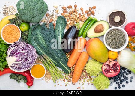 Vegan. Fruits Légumes lentilles épices herbes noix et graines sur un fond ardoise blanc Banque D'Images