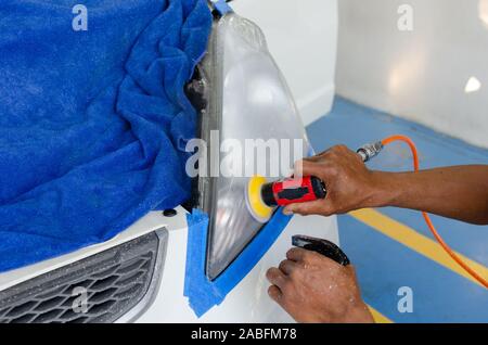 La main du mécanicien est le polissage de voiture phare. Banque D'Images