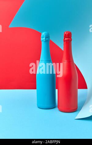 Création de deux bouteilles de vin de mock-up de pulvérisation peint rouge et bleu sur un fond ondulé duotone avec place pour le texte. Banque D'Images