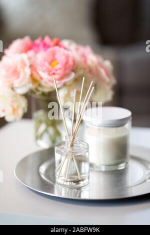 Diffuseur d'arôme, bougie et des fleurs sur la table Banque D'Images