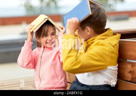 Les enfants de l'école avec des livres s'amuser en plein air Banque D'Images