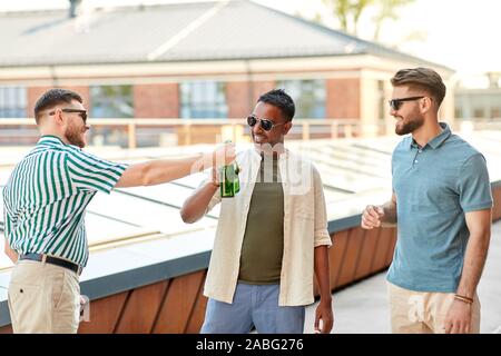 Heureux amis drinking beer at rooftop party Banque D'Images