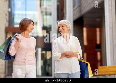 Les femmes âgées avec des sacs de shopping en ville à pied Banque D'Images