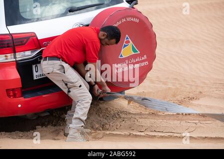 Un 4X4 Land Cruiser permet de tirer un autre Land cruiser qui avait coincé au sommet d'une dune de sable dans le désert du Sahara, Dubaï Banque D'Images