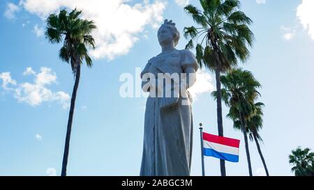 Belle vue de la Statue de la reine Wilhelmine avec pavillon néerlandais et de palmiers tropicaux comme arrière-plan Banque D'Images