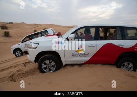 Un 4X4 Land Cruiser permet de tirer un autre Land cruiser qui avait coincé au sommet d'une dune de sable dans le désert du Sahara, Dubaï Banque D'Images