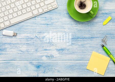 Bureau avec une tasse à café vide, papier collant, clavier de l'ordinateur clé USB et d'outils de mise à plat avec fond copy space Banque D'Images