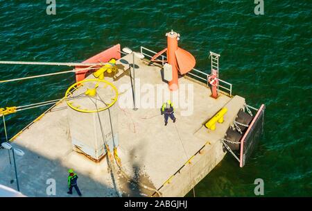 Les dockers du navire amarré hawser à shoreside bitt à quai du port Banque D'Images