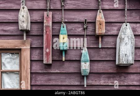 Libre de flotteurs colorés étendus dehors une petite maison de pêcheur. L'image est tannée pour ajouter un effet Banque D'Images