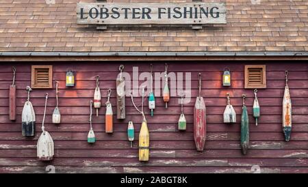 Libre de flotteurs colorés étendus dehors une petite maison de pêcheur de homard. Banque D'Images