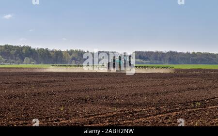 Le tracteur d'aspersion sur terre labourée. Banque D'Images