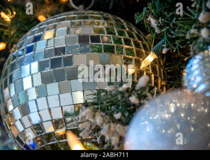 Ornements de Noël d'argent suspendu à un sapin Noël. Boule disco ornement. Arrière-plan approprié pour un format standard carte de Noël. Banque D'Images