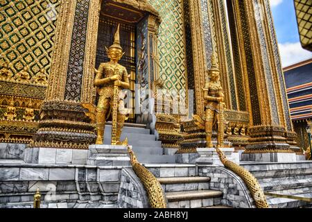 Or magnifiquement superbe statue d'un Kinnara, un être à moitié humain mythique, mi-créature oiseau sur la terrasse supérieure du Wat Phra Keo ou Temple du th Banque D'Images