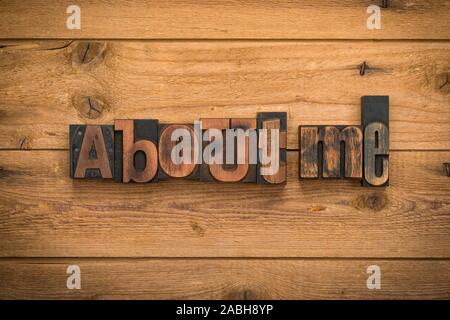 A propos de moi, une phrase écrite avec la typographie vintage blocks sur fond de bois rustique. Banque D'Images