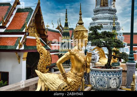 Or magnifiquement superbe statue d'un Kinnara, un être à moitié humain mythique, mi-créature oiseau sur la terrasse supérieure du Wat Phra Keo ou Temple du th Banque D'Images