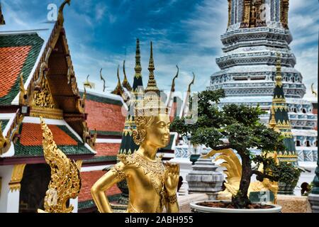 Or magnifiquement superbe statue d'un Kinnara, un être à moitié humain mythique, mi-créature oiseau sur la terrasse supérieure du Wat Phra Keo ou Temple du th Banque D'Images