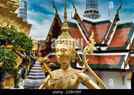 Or magnifiquement superbe statue d'un Kinnara, un être à moitié humain mythique, mi-créature oiseau sur la terrasse supérieure du Wat Phra Keo ou Temple du th Banque D'Images