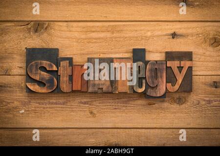 Stratégie, seul mot écrit avec la typographie vintage blocks sur fond de bois rustique. Banque D'Images