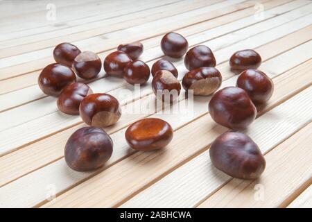 Dispersés sur une table en bois haut de la pile de fruits châtaignes. Banque D'Images