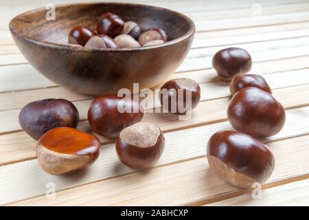 Dispersés dans le plat sur la table en bois haut de la pile de fruits châtaignes. Banque D'Images