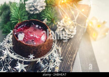 Petits gâteaux au chocolat farci de confiture de petits fruits sur la table de Noël. Banque D'Images