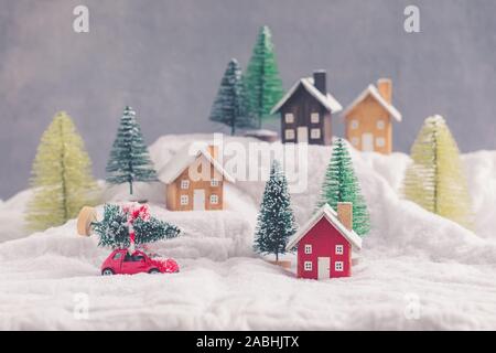 Maisons en bois miniature plus floue décoration de Noël, voiture rouge, les biens d'investissement immobilier concept salutations Banque D'Images