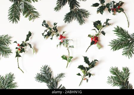 Naturel Noël motif floral. Composition des baies de houx rouge et vert sapin branches isolé sur fond blanc. Naturel d'hiver Banque D'Images