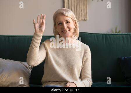 Femme âgée fait appel vidéo en agitant la main amie accueille Banque D'Images