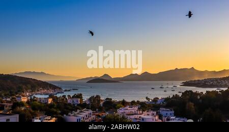 Coucher de soleil coloré lumineux dans la magnifique baie de la mer avec les îles, les montagnes, les bateaux et les oiseaux dans le ciel . Concept des vacances et voyage Banque D'Images