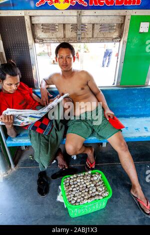 Un snack-vendeur voyageant sur le chemin de fer circulaire de Yangon, Yangon, Myanmar. Banque D'Images