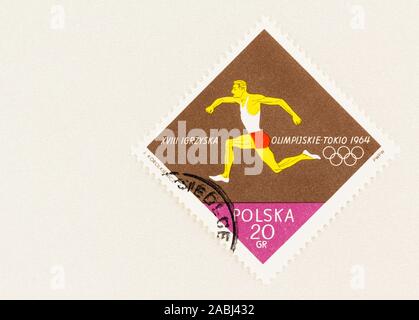 SEATTLE WASHINGTON - Le 9 octobre 2019 : coureur olympique timbres polonais sur bloc de couleur marron et de copier l'espace, commémorant les Jeux de Tokyo en 1964. Banque D'Images