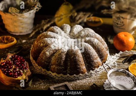 Gâteau de Noël traditionnel italien panettone pandoro torta poudrée d'vanille et décorée de dentelle sur table en bois Banque D'Images