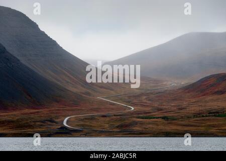 Route qui serpente à travers les montagnes, Pingeyri, Islande Banque D'Images