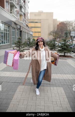 Nice happy woman holding shopping bags nombreuses Banque D'Images