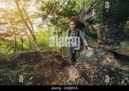 Hiker woman climbing up dans la forêt