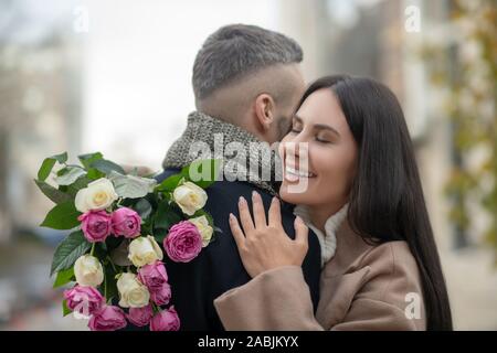 Heureux les jeunes de nice woman hugging son mari Banque D'Images