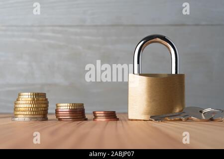 En ordre décroissant des piles de pièces en euro avec les lock cadenas doré. Les problèmes d'argent concept abstrait. Banque D'Images