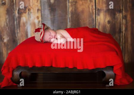 Mackay, Queensland, Australie - Novembre 2013 : la photographie nouveau-né de dormir bébé garçon sous couverture rouge portant chapeau de cow-boy en bonneterie Banque D'Images