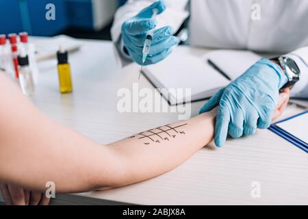 Portrait de l'allergologue gants en latex holding syringe près de femme tout en faisant l'essai clinique de l'allergie Banque D'Images