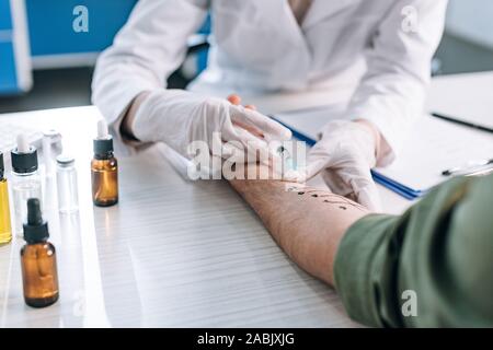 Focus sélectif de l'allergologue holding syringe près de marqués de la main patiente Banque D'Images