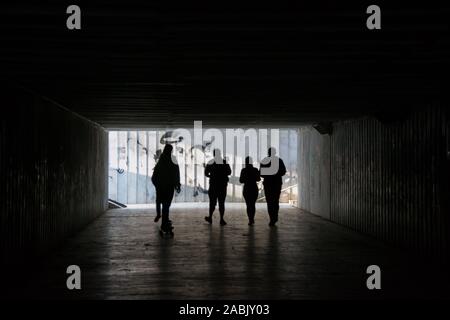 Les gens qui marchent à travers un passage souterrain sombre de fin, passage souterrain, personnes floues silhouettes Banque D'Images